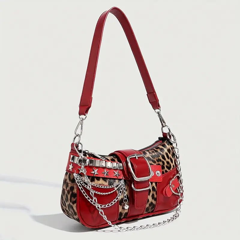 Red handbag with leopard print accents and chain details on a light gray background